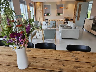 Woonkamer Land in Zicht met bloemen op tafel geplukt uit onze eigen tuinderij. Inspirerende ruimte huren Amersfoort.
