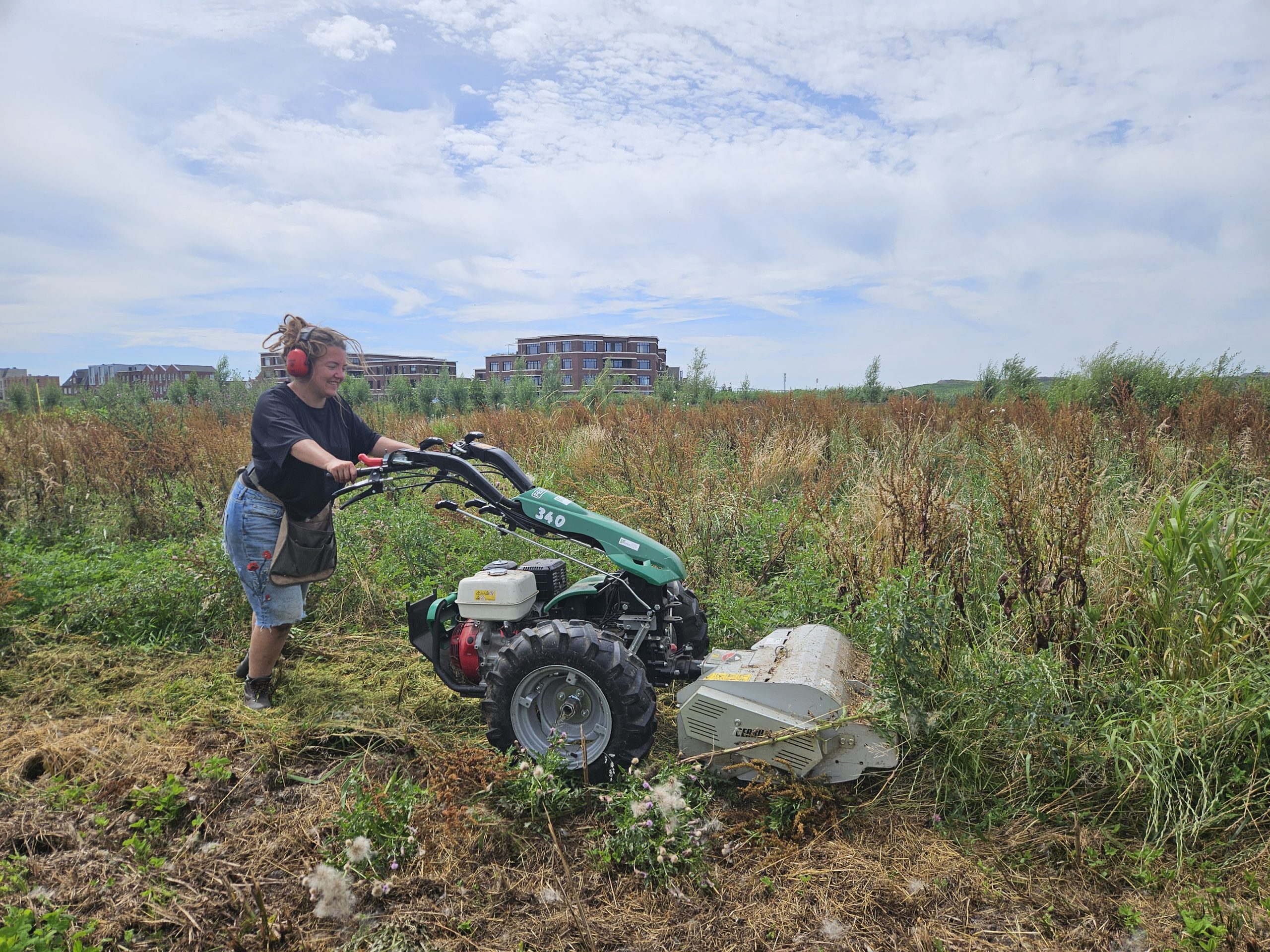 Student werkt mee op een de biodynamische Tuinderij van Land in Zicht tijdens een stage van Warmonderhof (Aeres MBO), omringd door groene velden, vers geoogste groenten en kleinfruit.