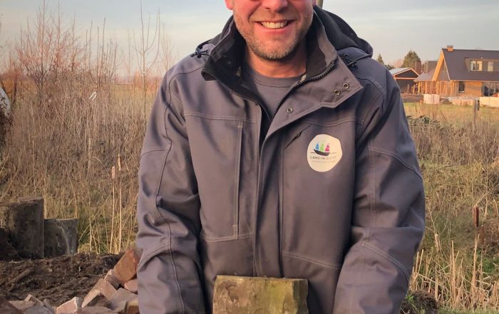 Hovenier Erik van Land in Zicht aan het werk in een ecologische tuin met inheemse beplanting.
