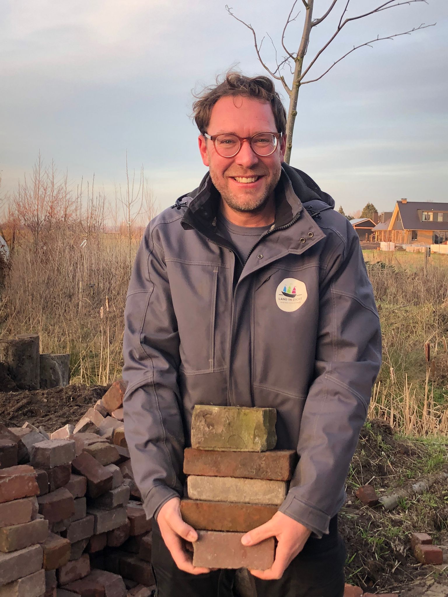 Hovenier Erik van Land in Zicht aan het werk in een ecologische tuin met inheemse beplanting.